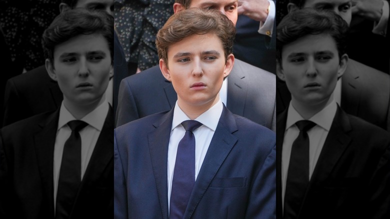 Barron Trump wearing a suit standing in front of Jared Kushner