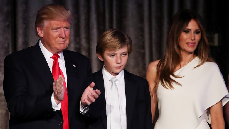 Barron Trump standing on stage between his parents at Trumps' 2016 election night event