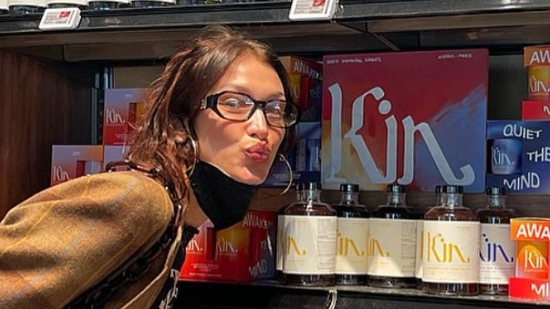 Bella Hadid posing beside Kin Euphorics beverages