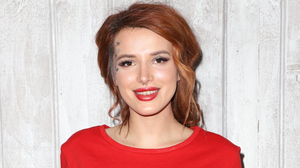 Bella Thorne with red hair pulled back and red lips