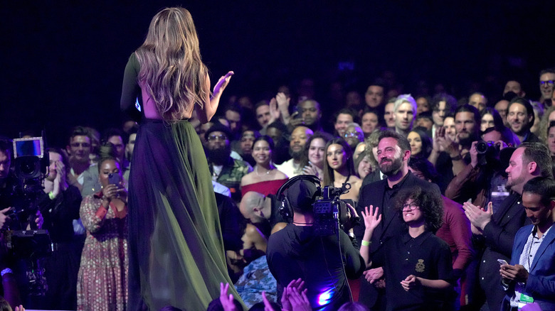 Ben Affleck smiles while watching Jennifer Lopez onstage