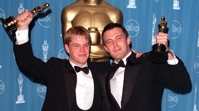 Matt Damon and Ben Affleck holding Oscars in 1998