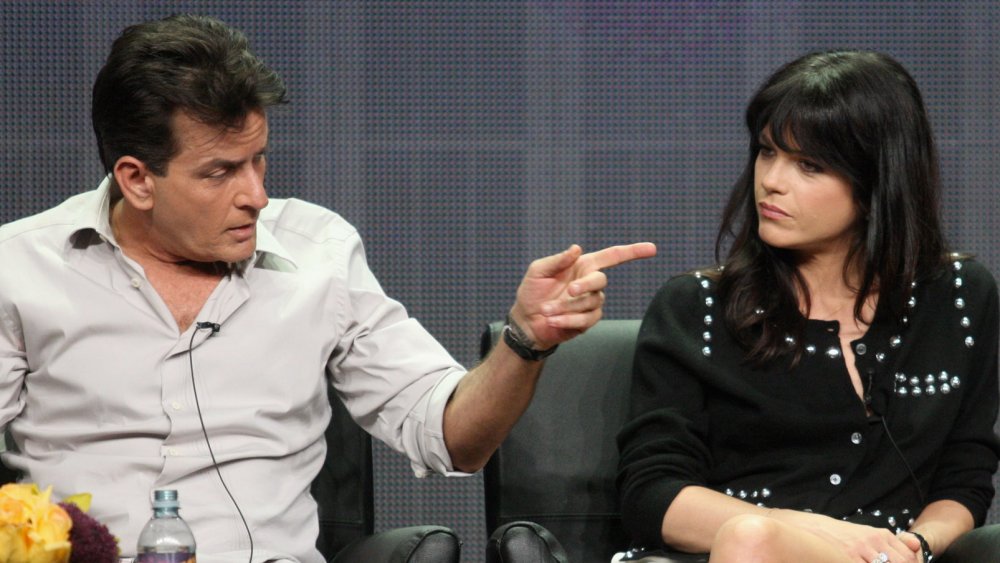 Charlie Sheen pointing at a solemn-looking Selma Blair during a panel interview