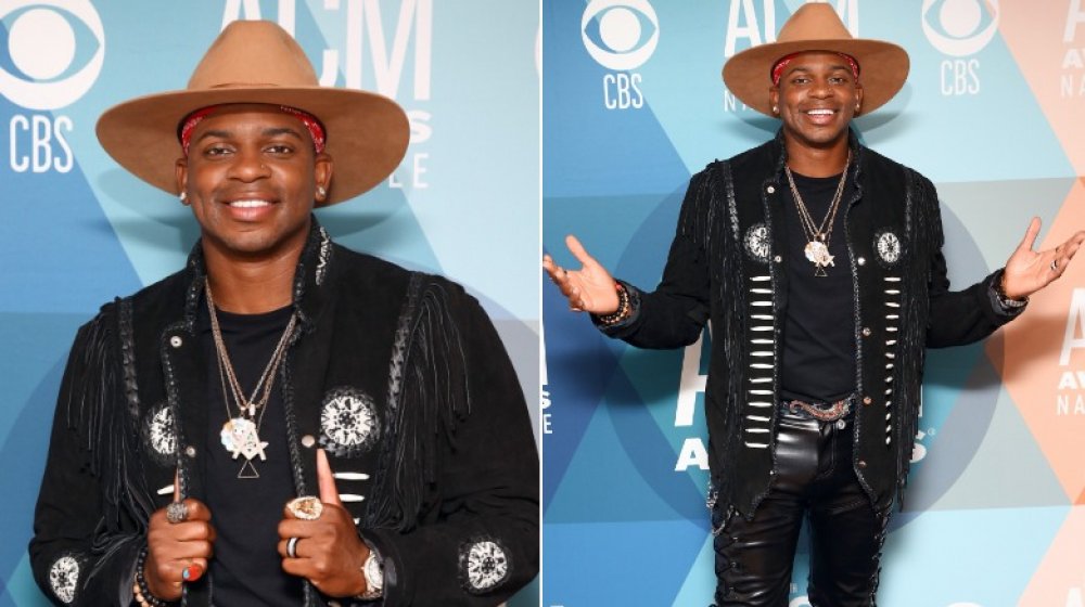 Jimmie Allen in brown wide-brim hat and black ensemble