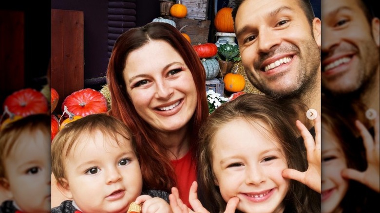 Rachel Reilly and Brendon Villegas pose for an autumn selfie with pumpkins in the background with their two kids