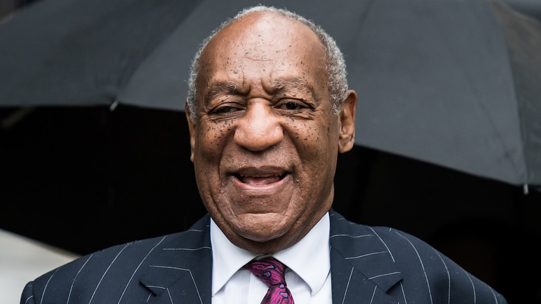 Bill Cosby smiling in suit and tie