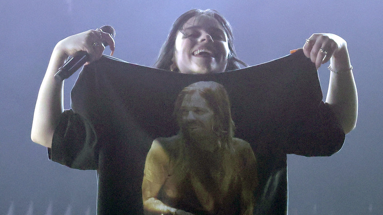 Billie Eilish holding up her shirt 