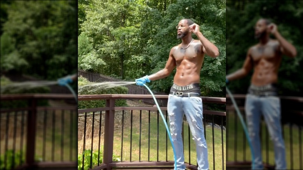 Safaree Samuels hosing off a deck shirtless 