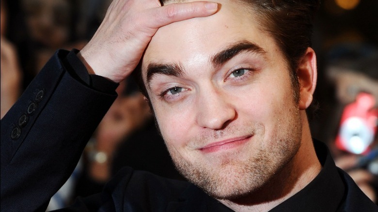 Robert Pattinson clutching head