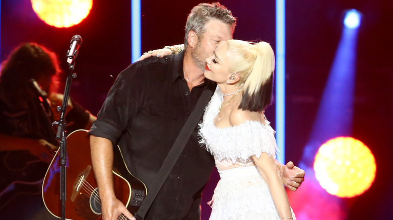 Blake Shelton kissing Gwen Stefani on stage