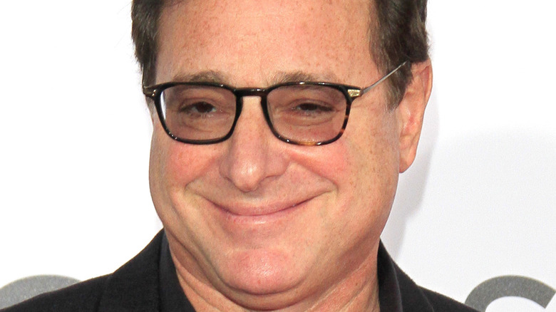 Bob Saget smiling big, mouth closed