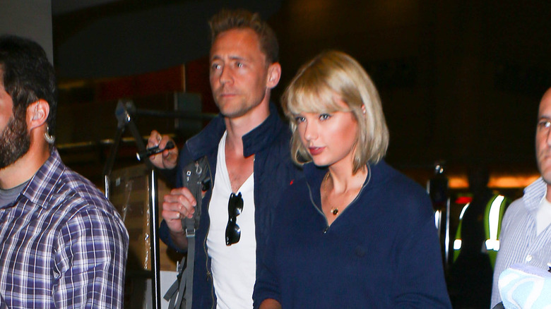 Tom Hiddleston walking beside Taylor Swift