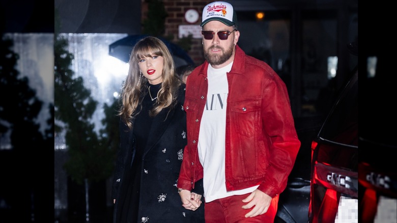 Taylor Swift holding hands with Travis Kelce