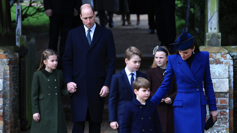 Kate Middleton, Prince William, and their children walking in park