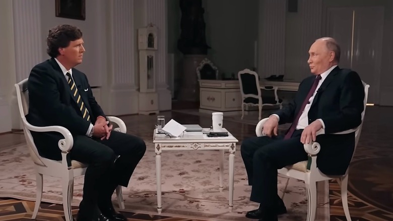 Tucker Carlson and Vladimir Putin sit across from each other