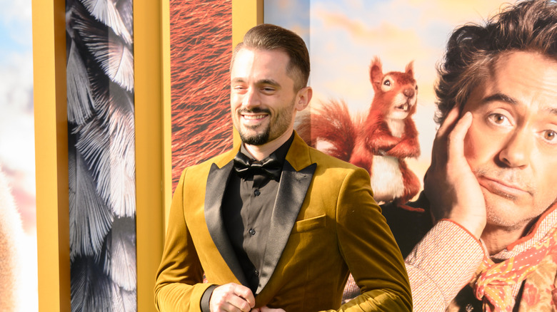 Brad Lambert posing  in gold and black suit