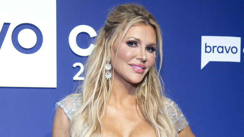 Brandi Glanville smiling, flower earrings