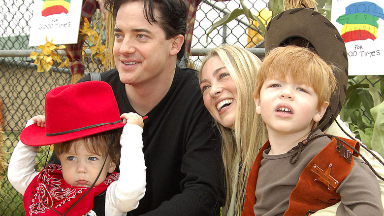 Afton Smith and Brendan Fraser posing with two sons