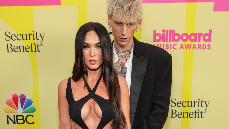 Megan Fox and Machine Gun Kelly stare ahead at the Billboard Music Awards