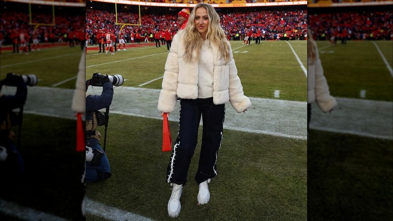 Brittany Mahomes wearing a white fur coat on the sidelines