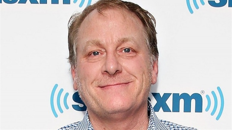 Curt Schilling poses in front of a step and repeat