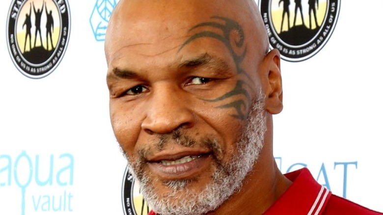 Mike Tyson posing in front of a step and repeat