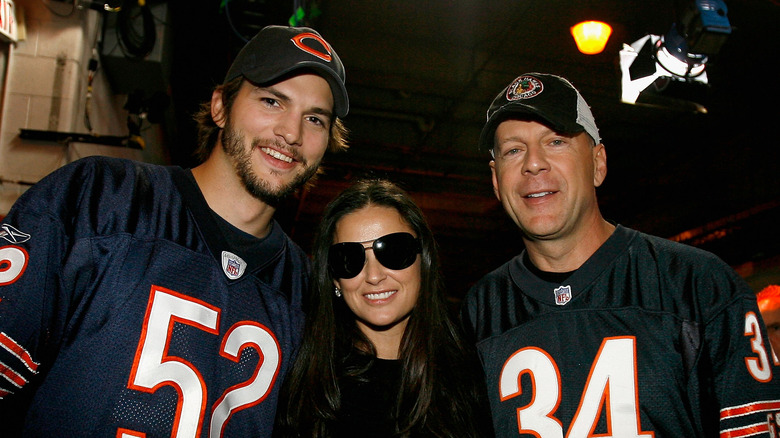 Ashton Kutcher and Bruce Willis posing at a sport event