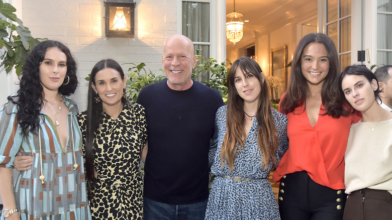 Bruce Willis smiling with his children and Demi Moore