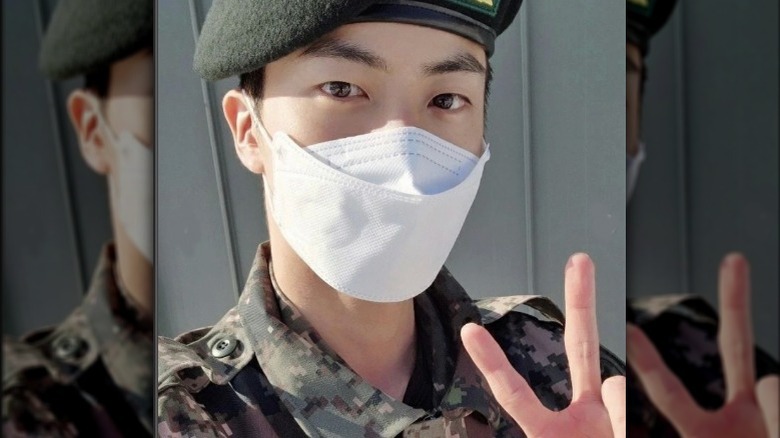 BTS Jin in military uniform mask flashing peace sign