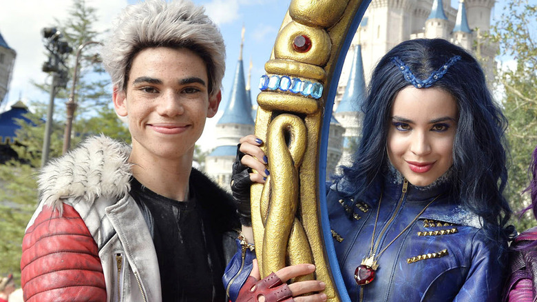 Cameron Boyce as Carlos and Sofia Carson as Evie smiling together in character