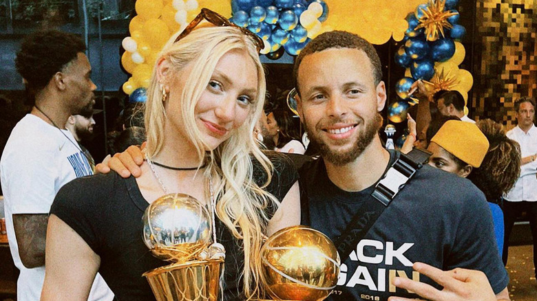 Cameron Brink and Steph Curry holding trophies