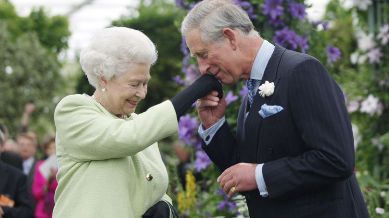 Prince Charleskissing Queen Elizabeth's hand