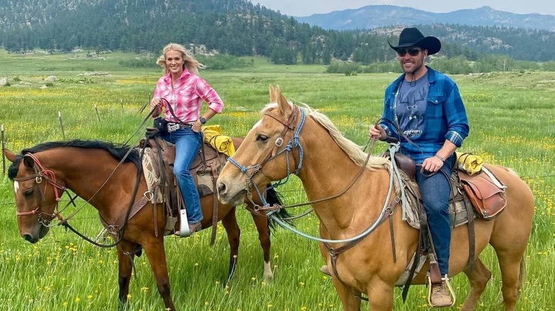 Carrie Underwood and Mike Fisher riding horses on a ranch.