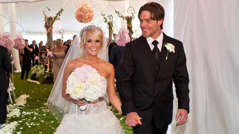 Carrie Underwood and Mike Fisher walking down the aisle on their wedding day.