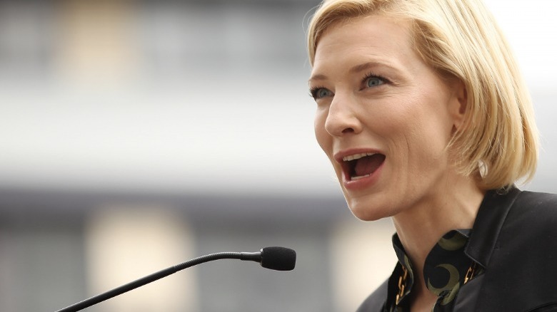 Cate Blanchett speaking at a press conference microphone