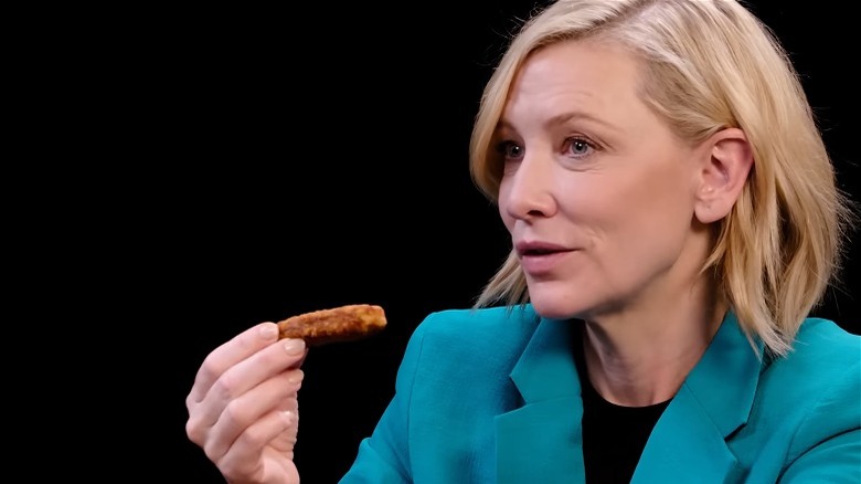 Cate Blanchett holding a vegan wing blue suit