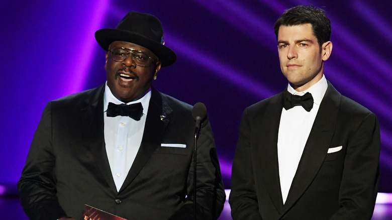 Cedric the Entertainer and Max Greenfield speaking onstage during the 71st Emmy Awards