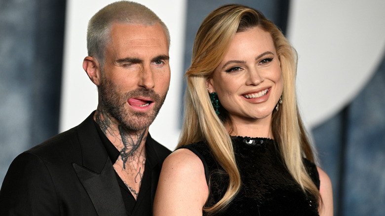 Adam Levine sticking tongue out, Behati Prinsloo smiling