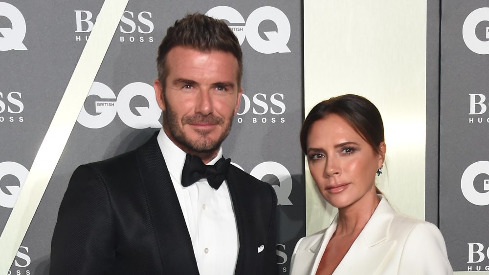 David Beckham in formal attire next to Victoria Beckham