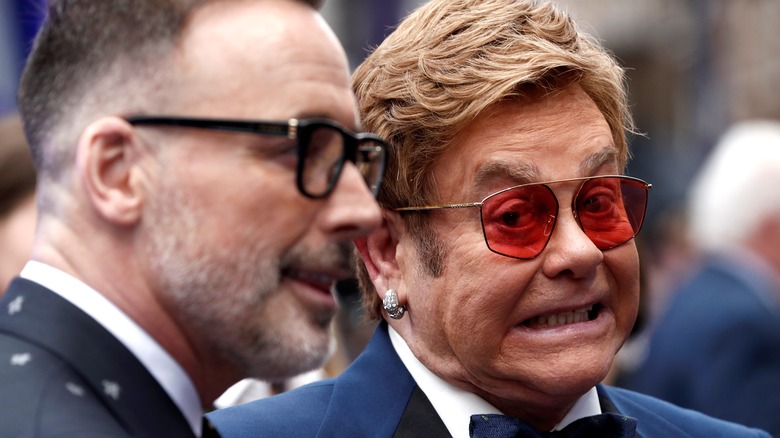 Elton John pulling a face next to David Furnish