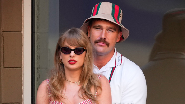 Travis Kelce wearing bucket hat behind Taylor Swift at 2024 US Open