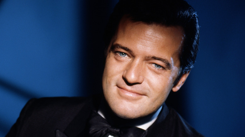 Robert Goulet smiling in tuxedo with blue backdrop