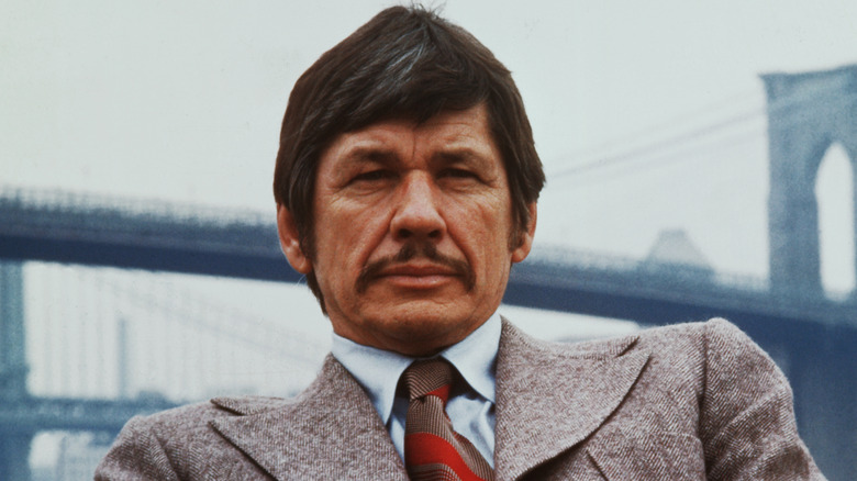 Charles Bronson seated in wool suit