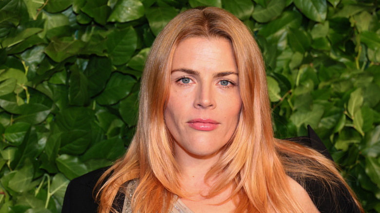 Busy Philipps posing in front of greenery 