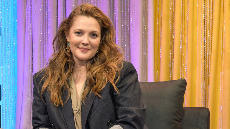 Drew Barrymore sitting in a chair 