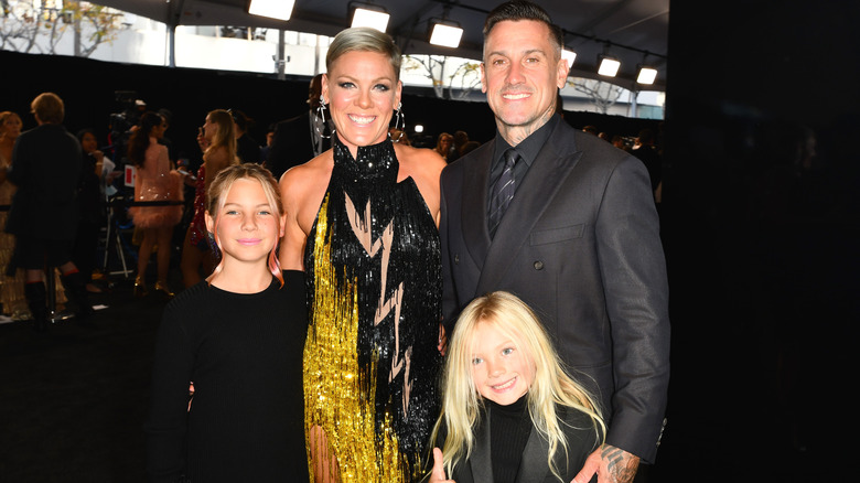 Pink, Carey Hart and their kids posing at an event