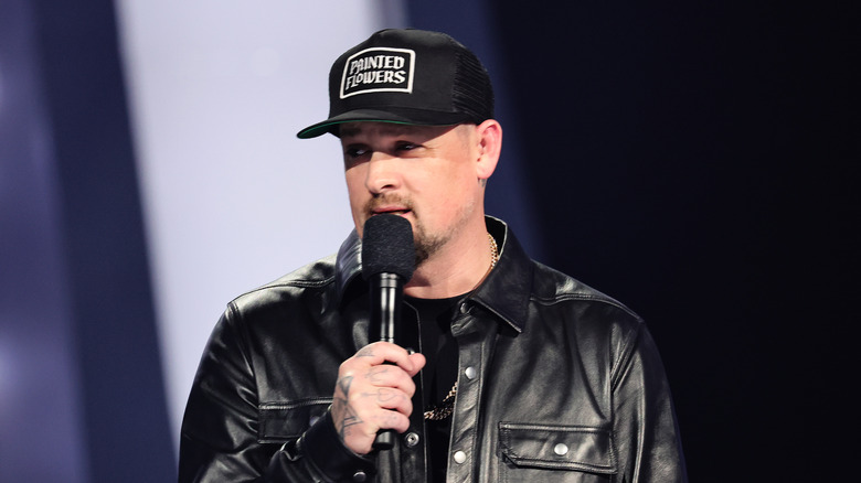 Joel Madden holding a microphone