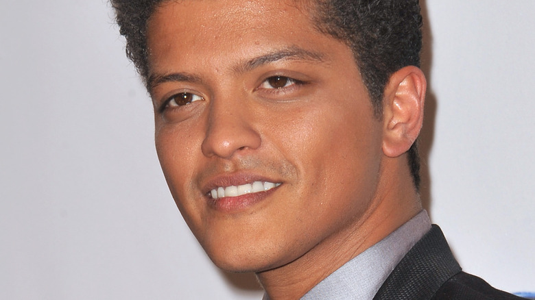 Bruno Mars in suit smiling 