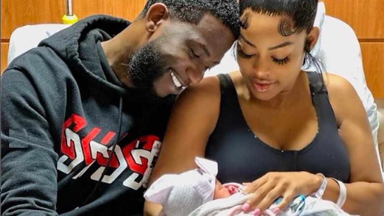 Gucci Mane and Keyshia Ka'oir Davis smiling at newborn