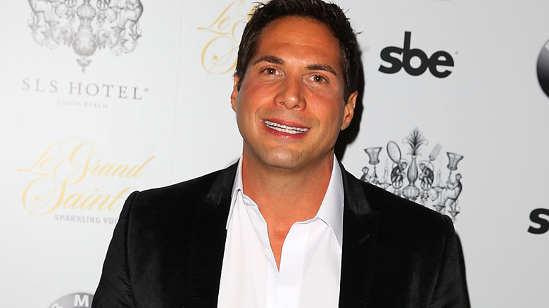 Joe Francis smiling, black suit